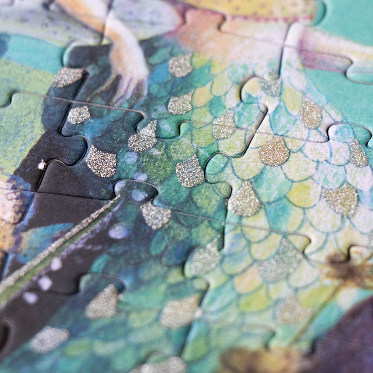 A close-up of the puzzle showing the shimmering glitter effect on a mermaid’s scaly tail.