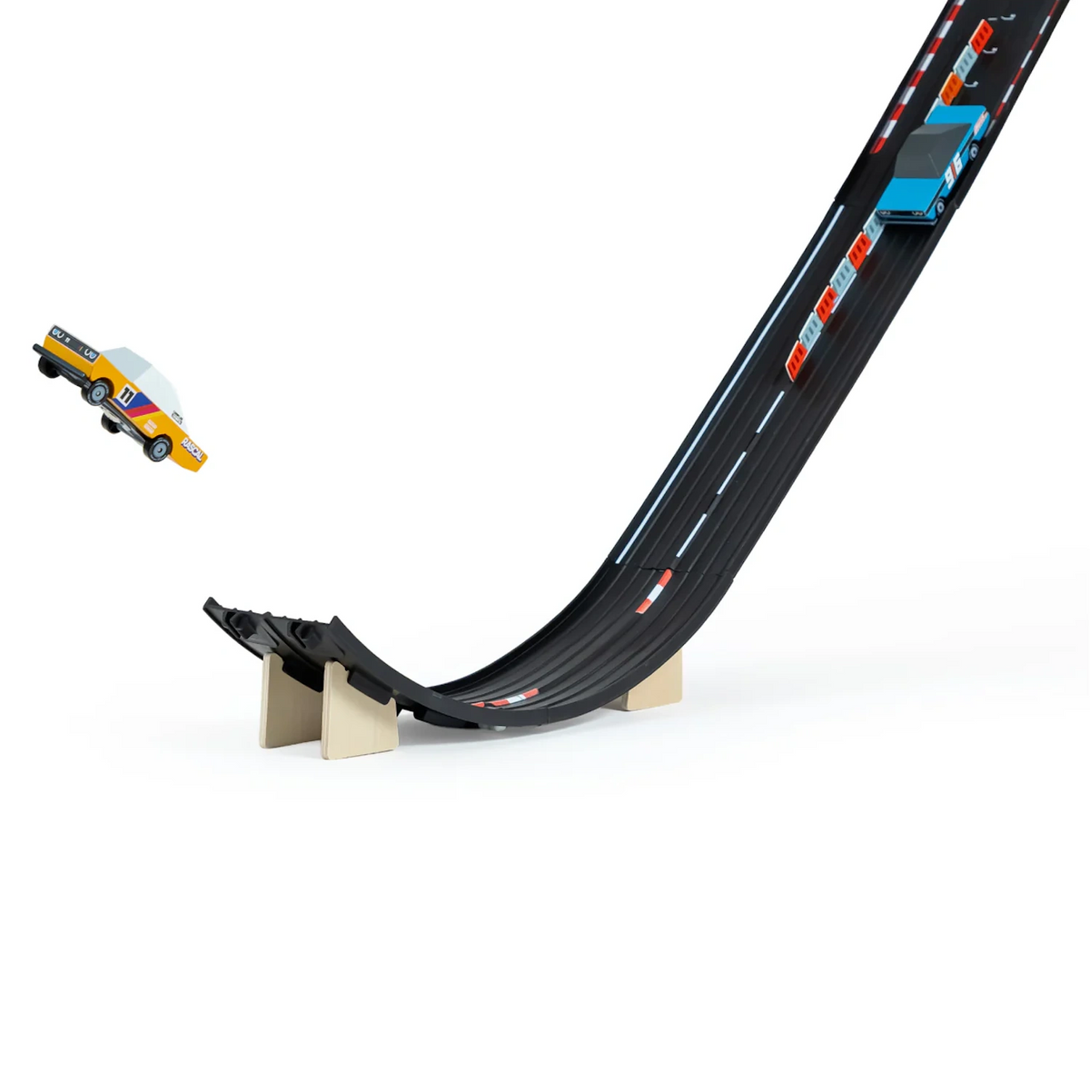 Close-up of Candylab Roadworks Speed Playset with a yellow wooden car jumping off a black toy racing ramp.