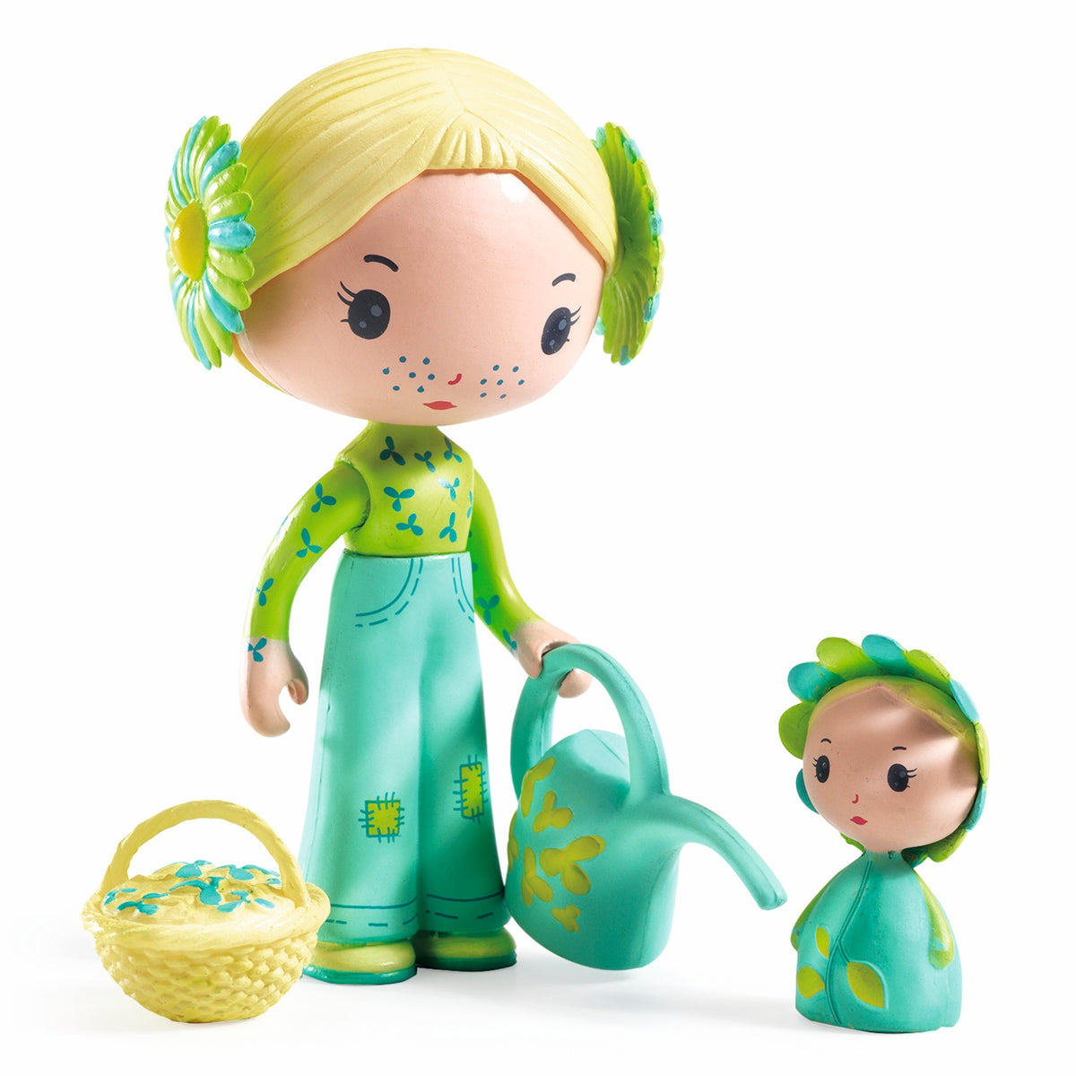 A whimsical figurine with blonde hair and floral accents holds a watering can beside a smaller flower-like figure and a decorative basket. Bright and playful.
