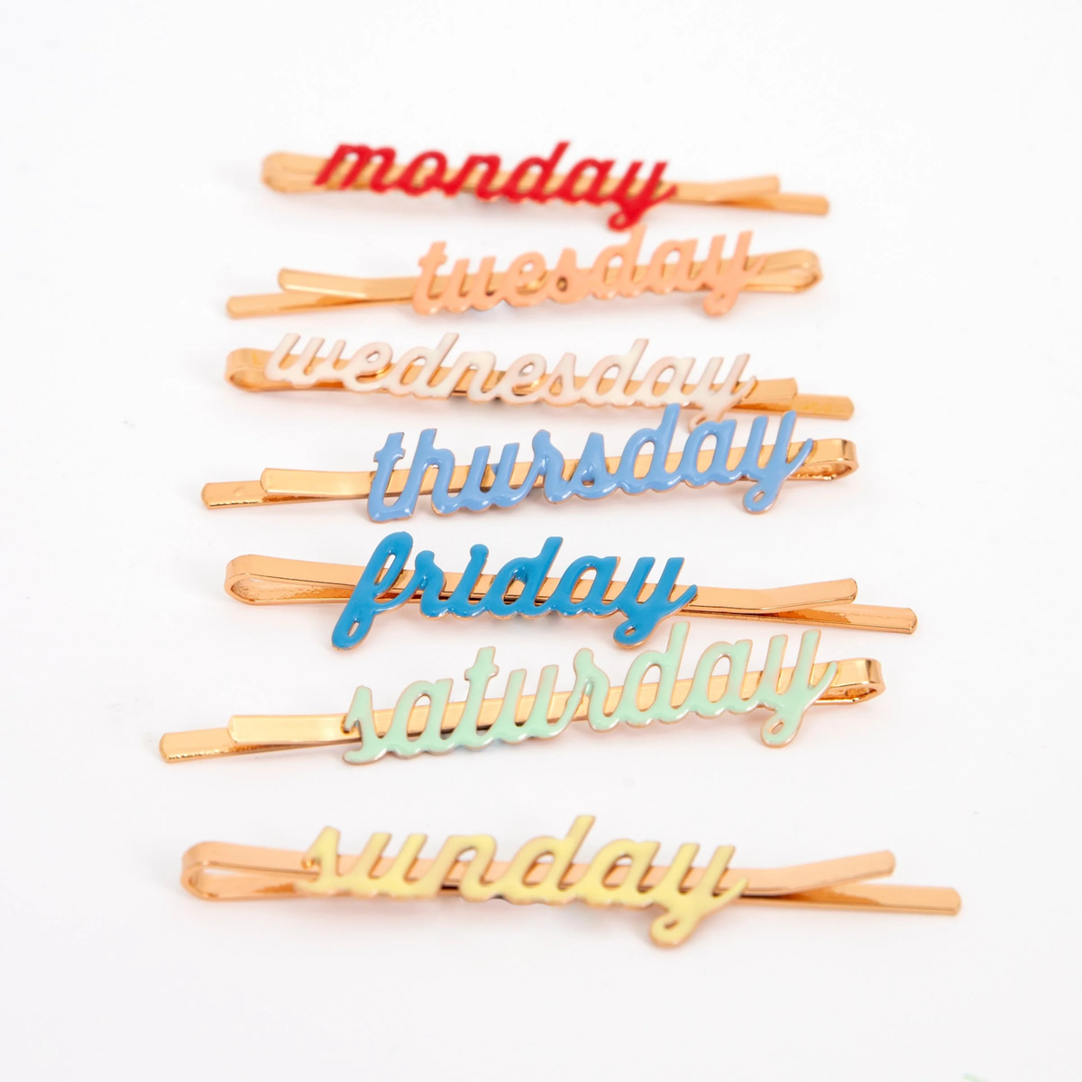 A set of enamel hair clips featuring the days of the week, perfect for adding a fun and functional touch to daily hairstyles.