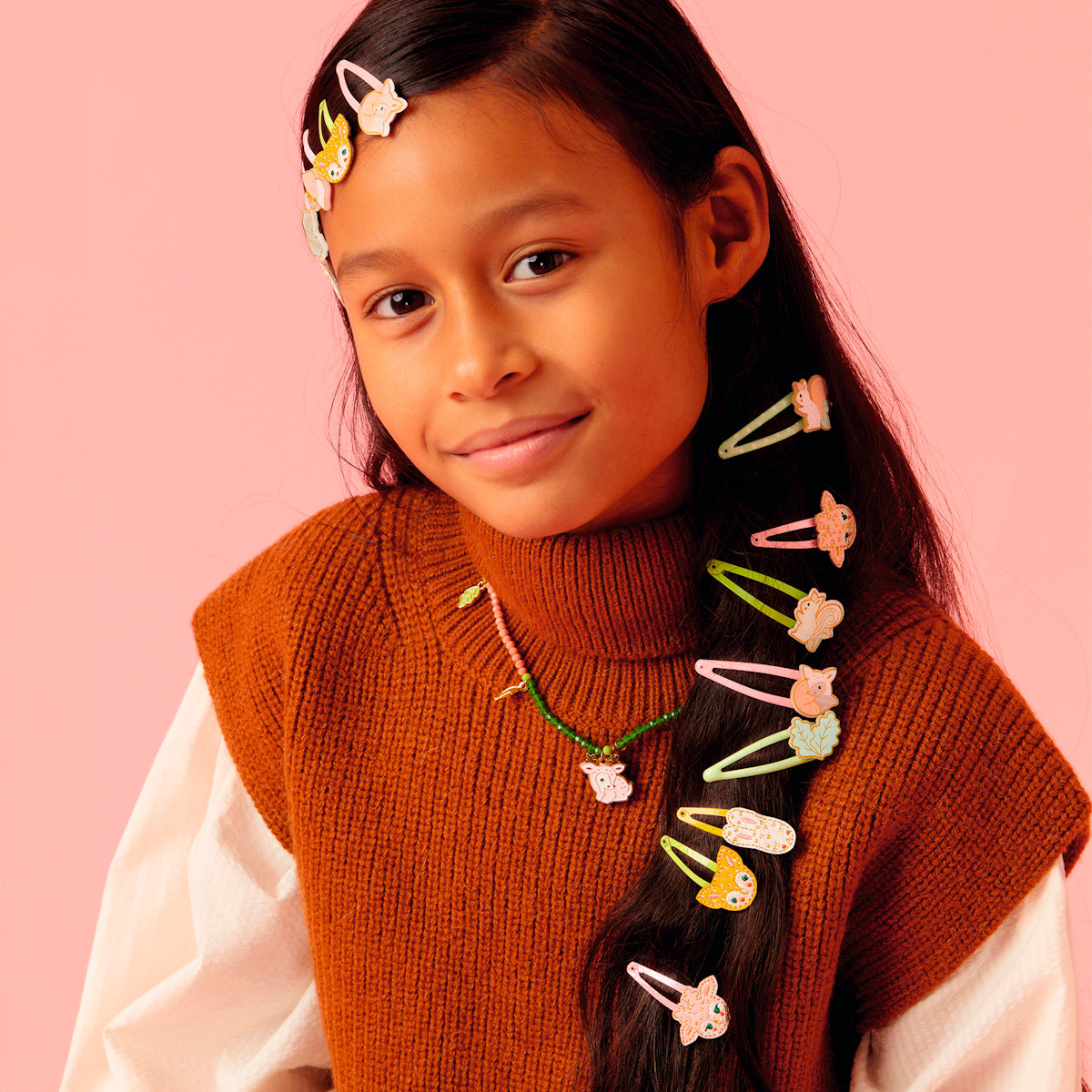 Girl wearing Sylvia forest collection deer necklace with mixed forest animal hair clips along long straight hair.