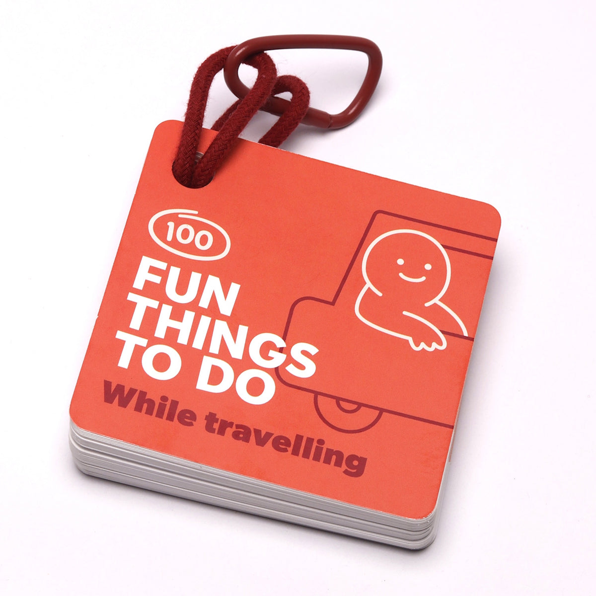 Orange card deck titled "100 Fun Things To Do While travelling" on a red clip and cord.