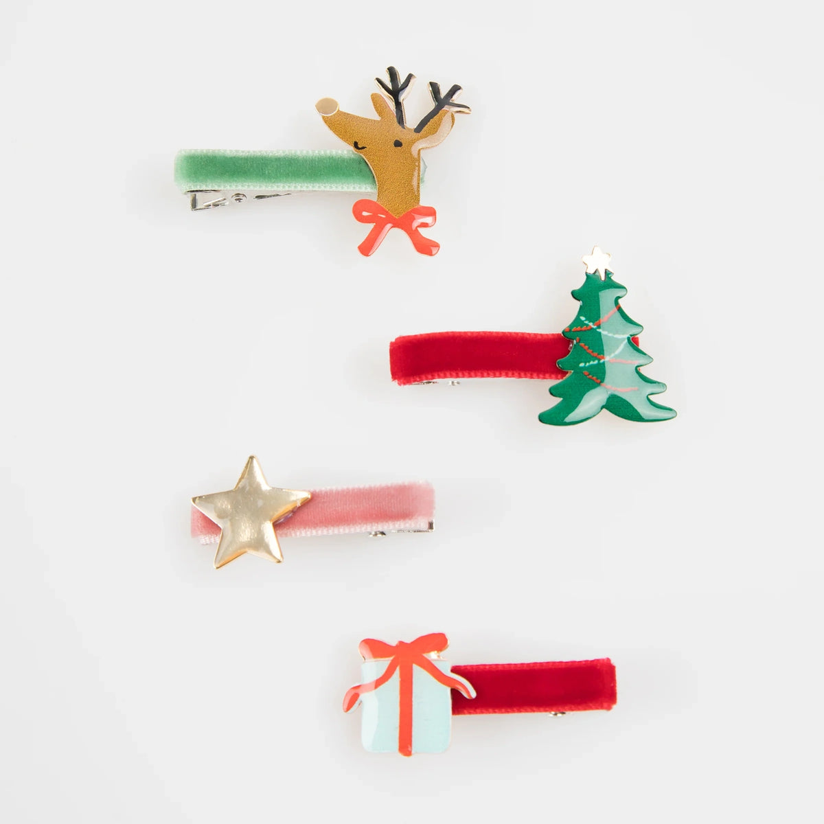 Four velvet Christmas hair clips featuring a reindeer, tree, star, and present charm.