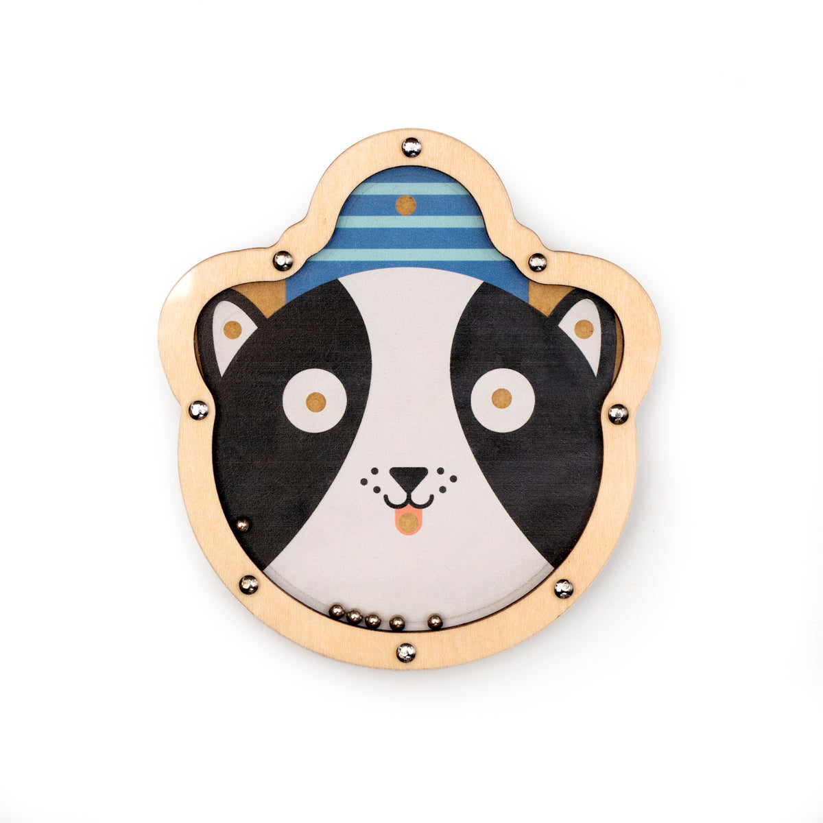 Wooden toy with a cartoon dog's face, featuring large eyes and a smiling mouth. It's outlined with metallic studs and includes small metal balls.