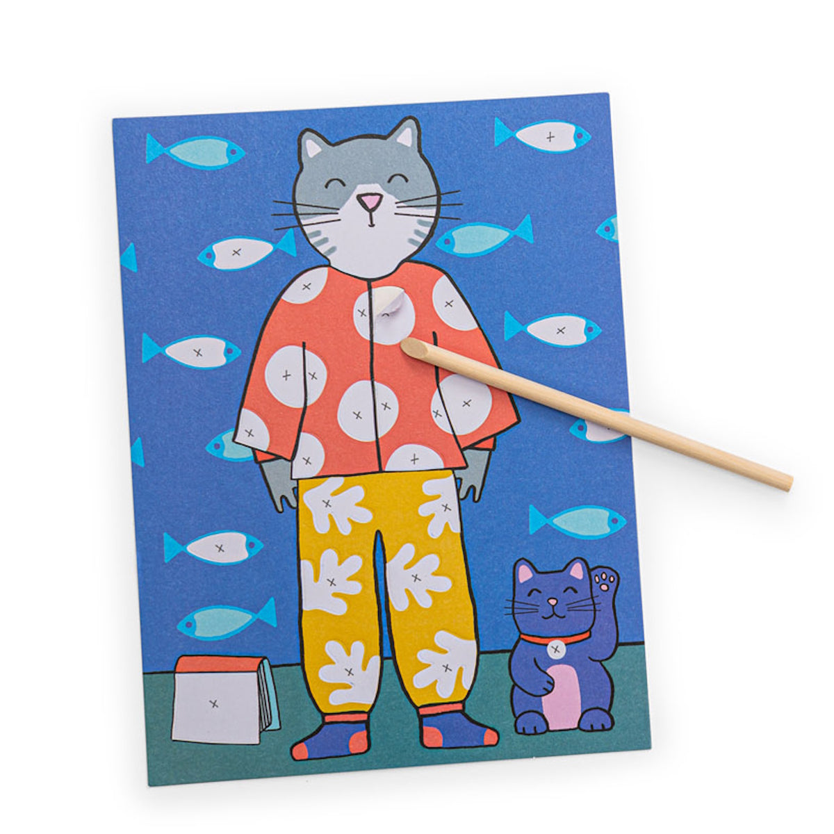Whimsical cat art board being decorated with a wooden tool, featuring fish patterns and a lucky cat figure.