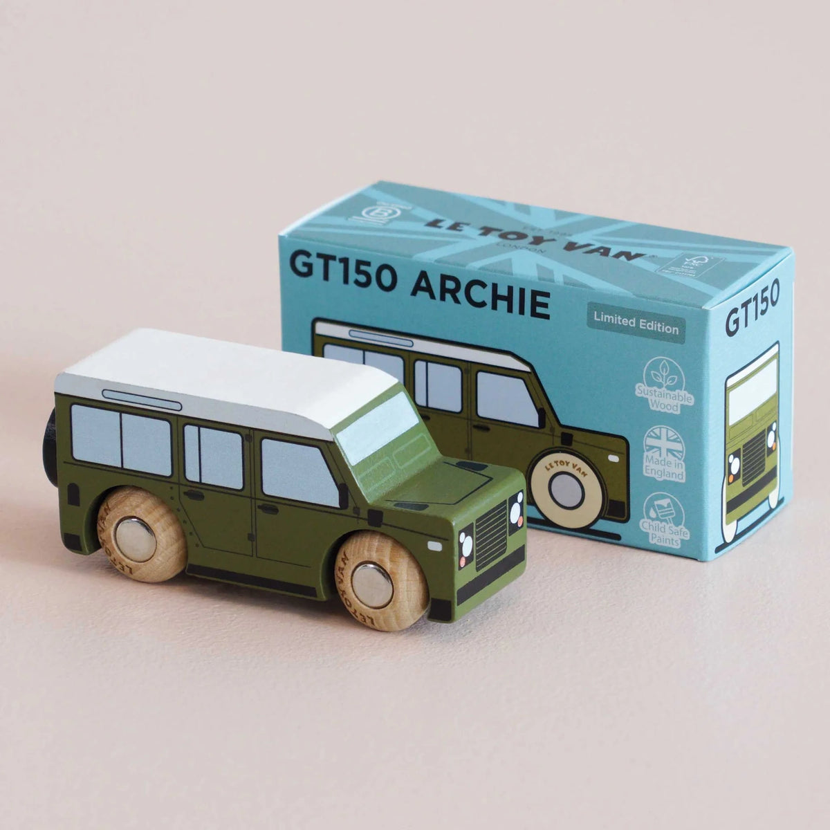 Front three-quarter view of a green wooden toy car displayed alongside its light blue packaging box.