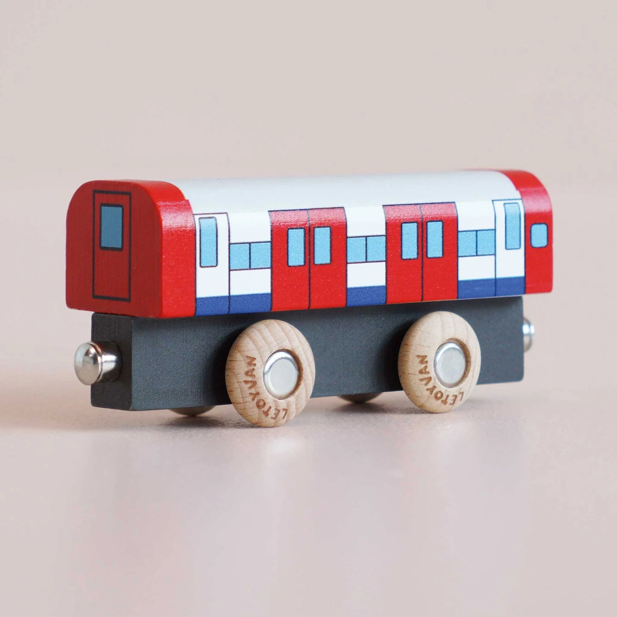 Rear view of a red, white, and blue wooden toy train carriage on a light background.