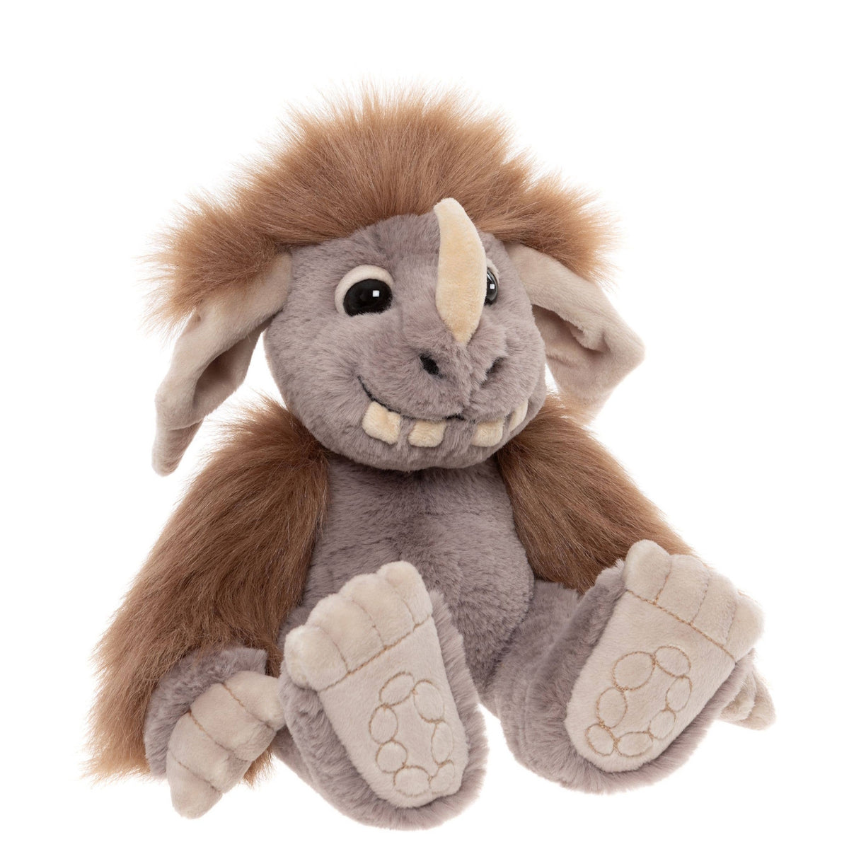 Plush monster toy with grey fur, brown mane, single horn, big floppy ears, and prominent teeth, sitting down.