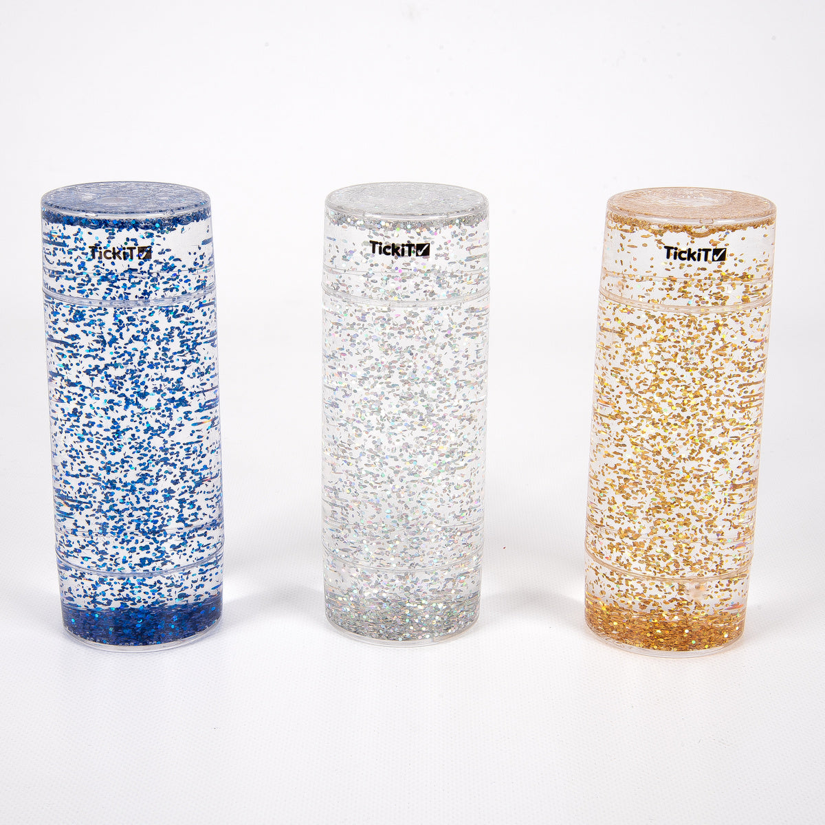 Three tall, clear cylinders filled with blue, silver, and gold glitter, set against a white background. Each has a black logo near the top.