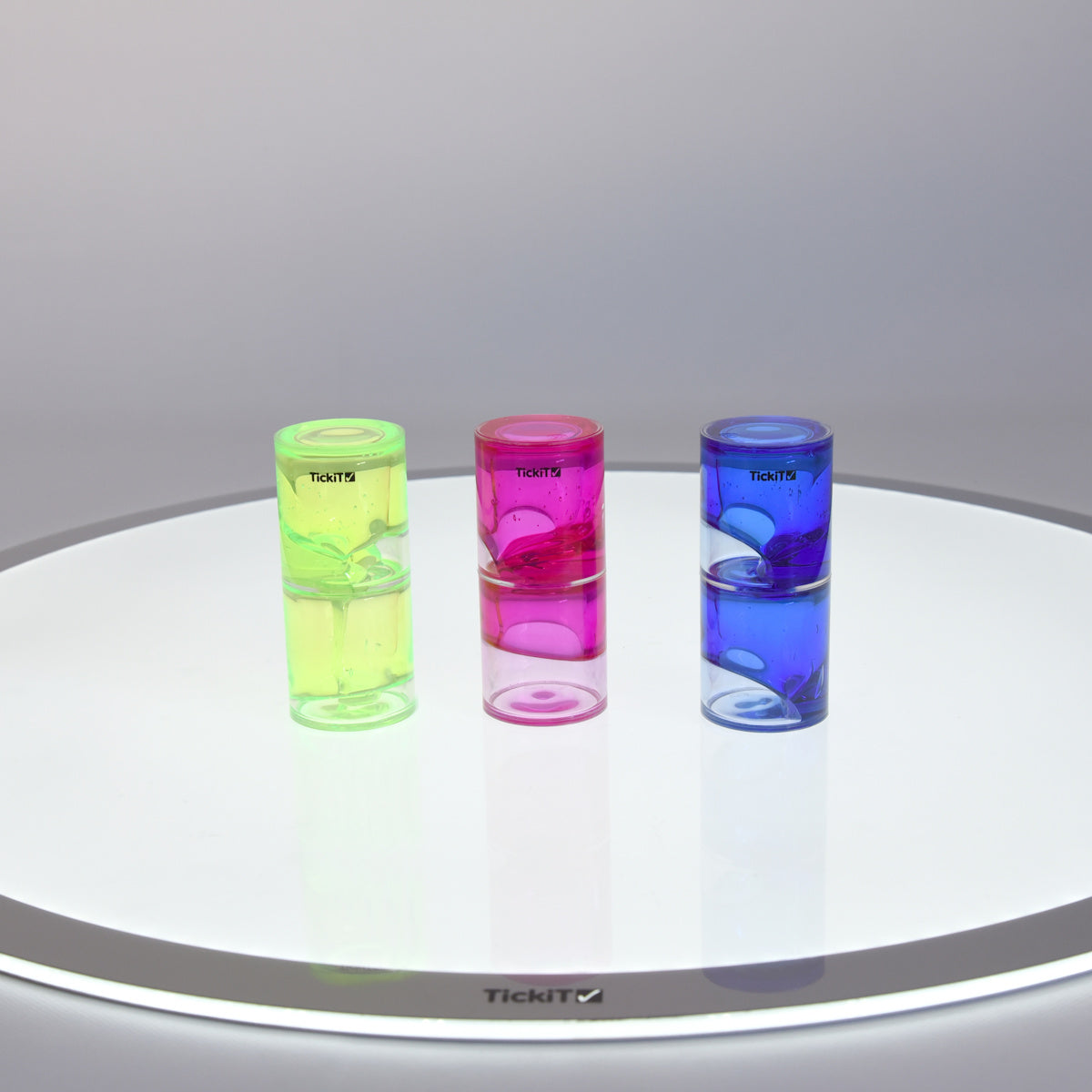 Three colorful liquid timers on a reflective surface: neon green, bright pink, and vivid blue. They convey a playful and dynamic mood.