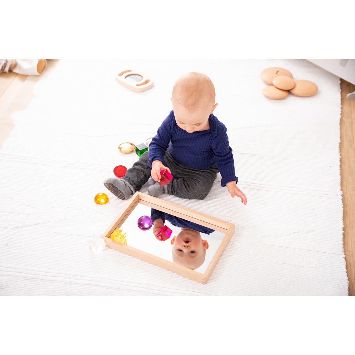 A compact wooden tray with a mirrored base, perfect for sensory play, loose parts exploration, and visual perception activities.