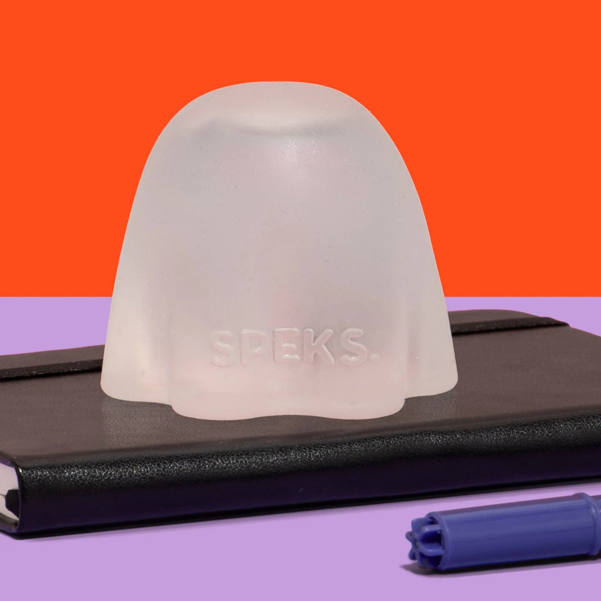 Front view of a translucent white silicone ghost container featuring the embossed text SPEKS on a black notebook.