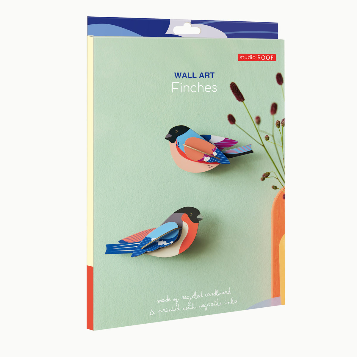 Packaging for Studio Roof's wall art, "Finches." Features colorful 3D bird models on a pale green background, with delicate dried flowers in a vase.