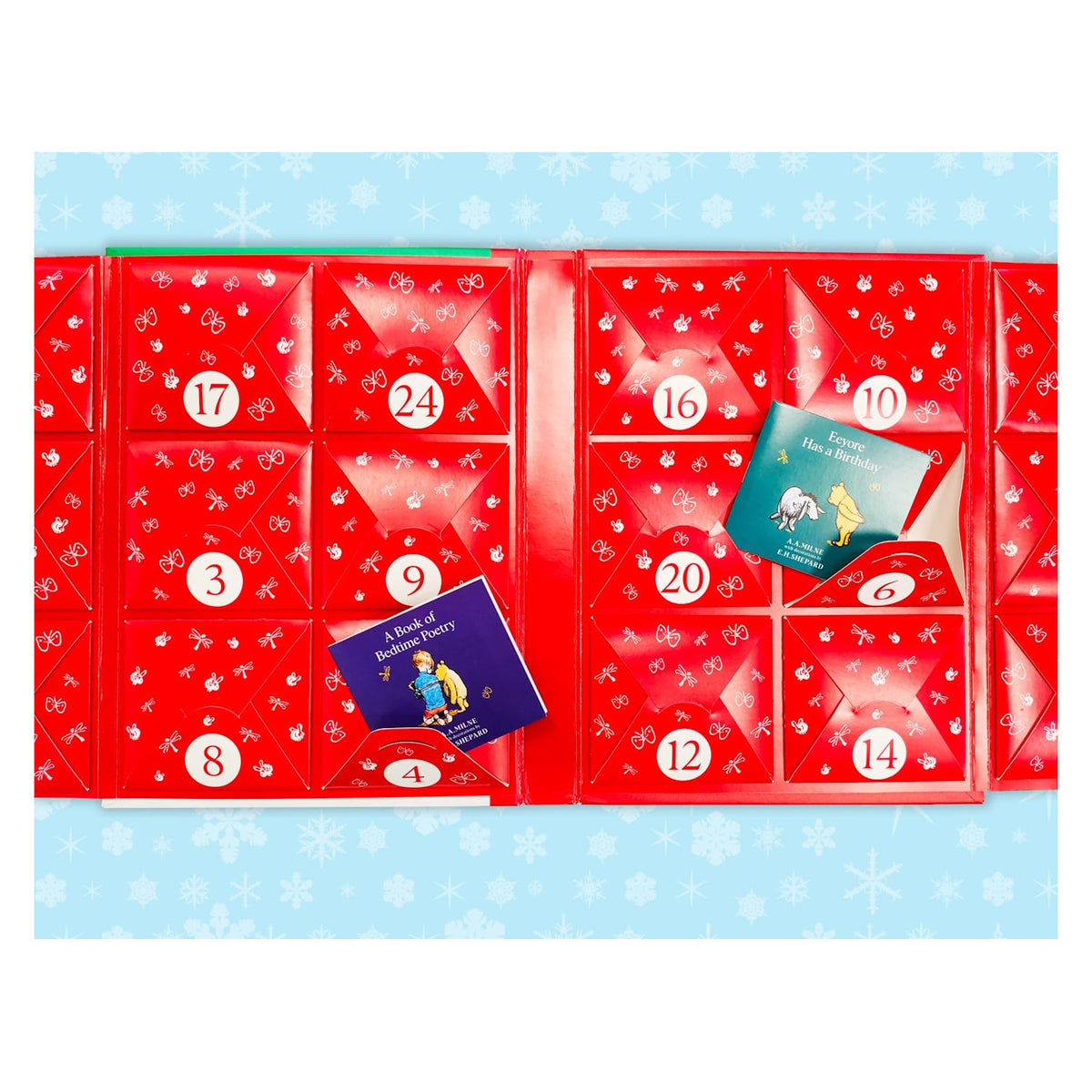 Flat lay view of open red Winnie-the-Pooh advent calendar pockets revealing mini books.
