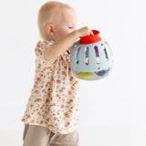 Side view of a toddler holding a light blue plastic toy curiosity lantern.