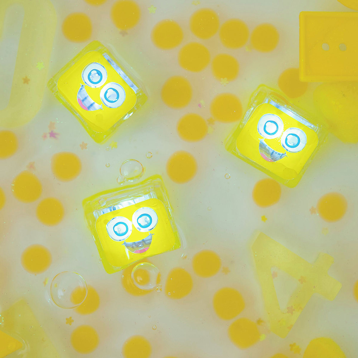 Yellow glowing sensory cubes floating in a water-filled sensory play area.