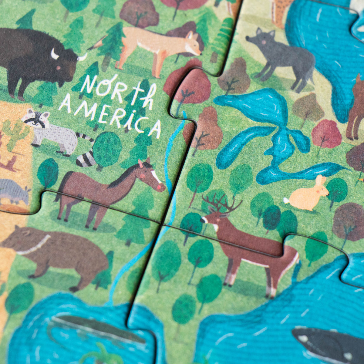 Close-up of the North America section of the puzzle, displaying animals like deer and raccoons.