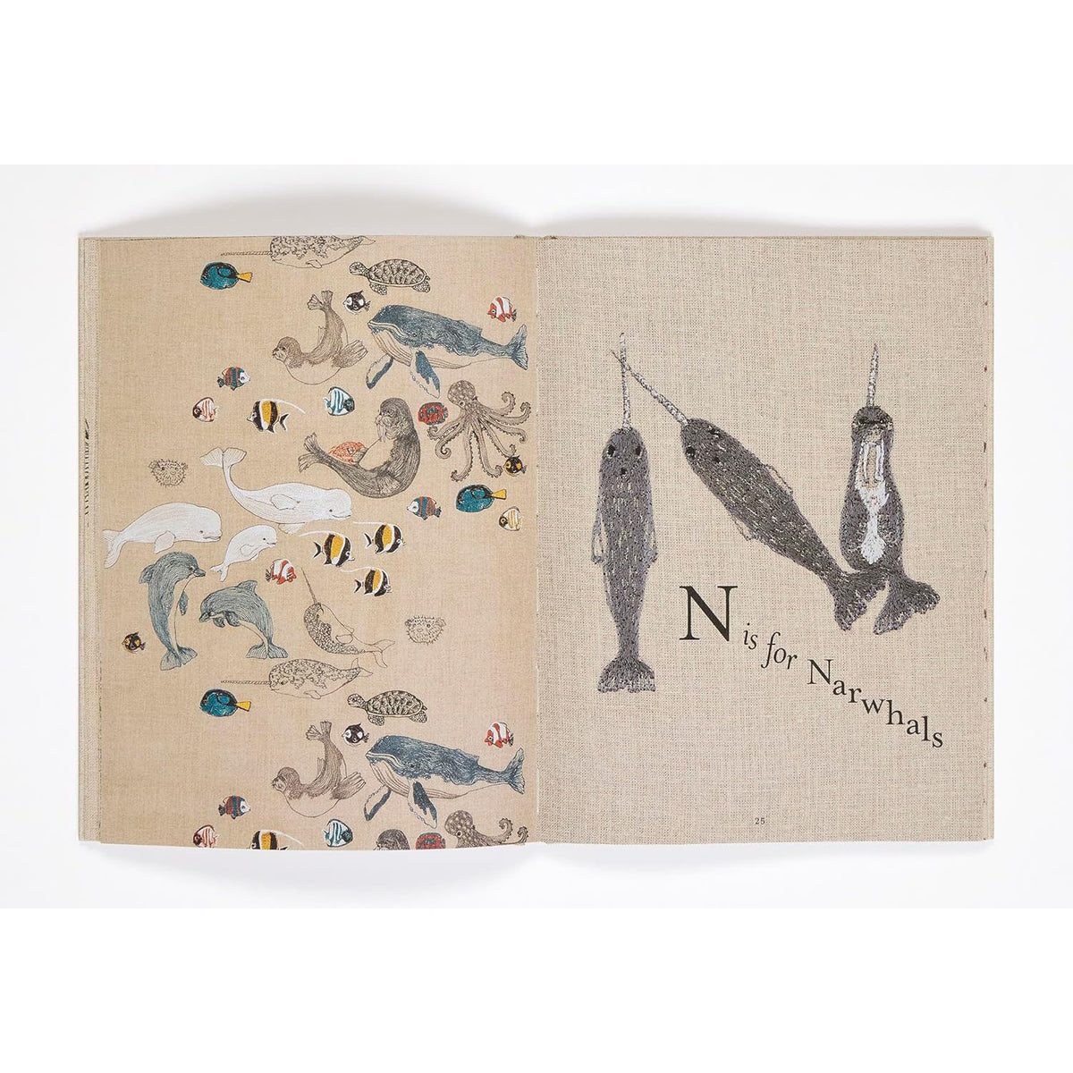 Children's book spread with sea creatures on the left and "N is for Narwhals" on linen-texture paper.