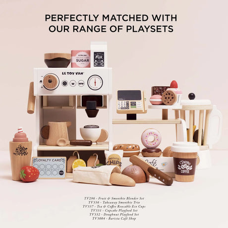 Le Toy Van wooden toy bakery set displayed alongside a matching barista cafe playset and various food toys.