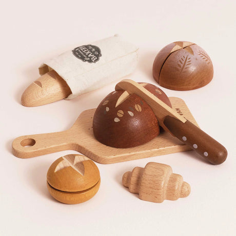 Wooden toy bakery set with a cutting board, toy bread loaves, a croissant, and a wooden knife.
