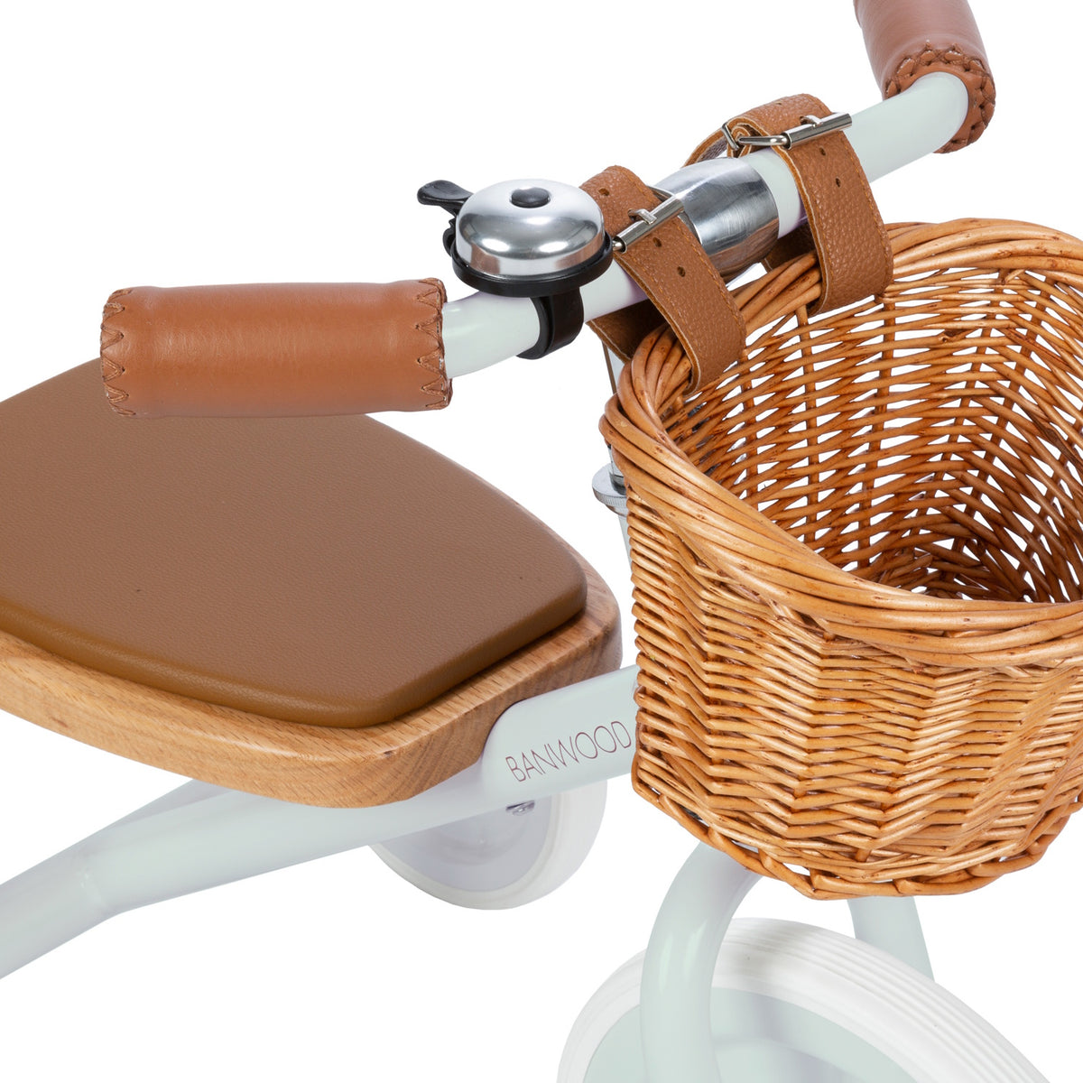 A vintage-inspired children's tricycle in a soft mint green, featuring a sturdy steel frame, wooden pedals, a removable push bar, and a wicker basket.