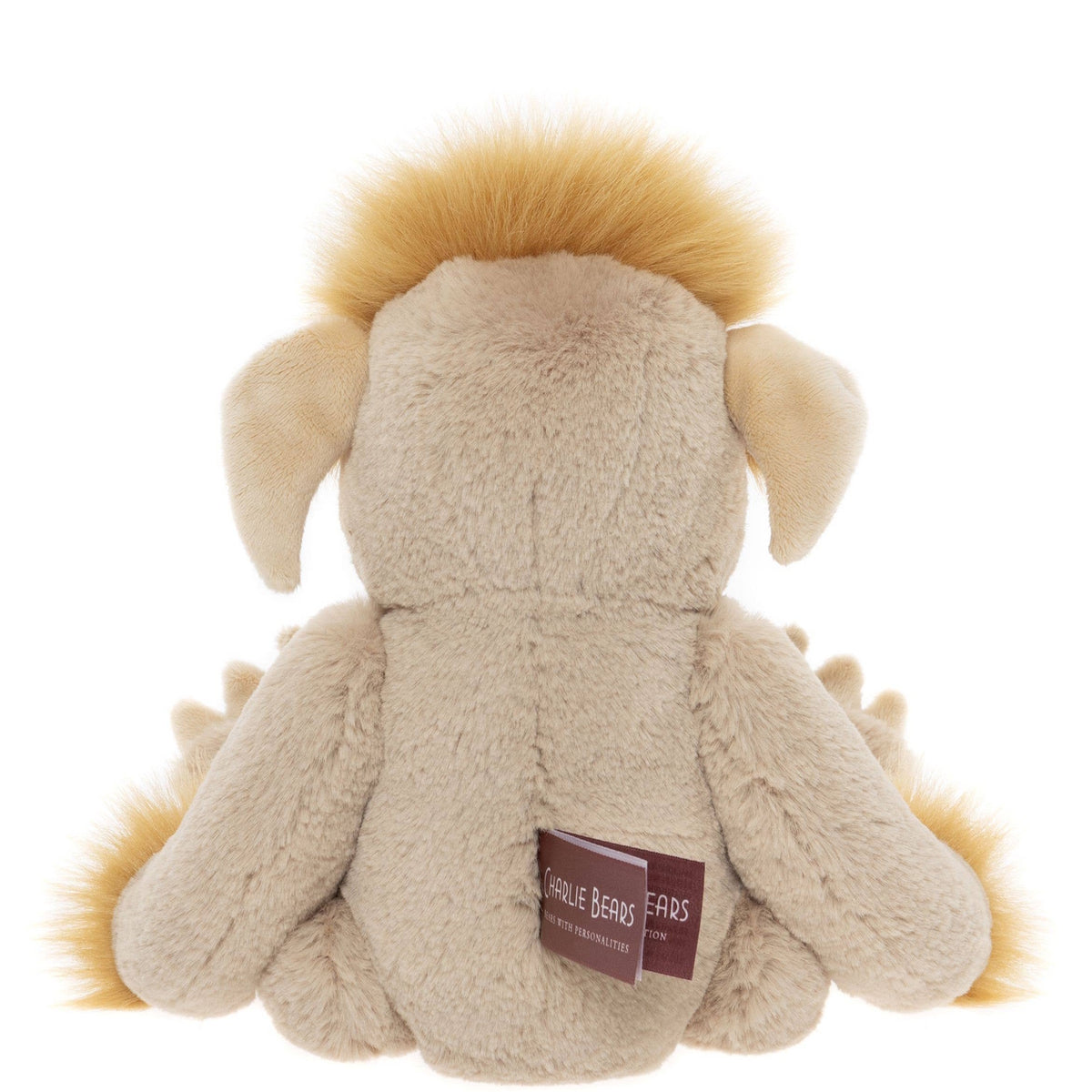 Back view of a seated beige plush creature toy featuring fluffy yellow hair, floppy ears, and a fabric tag.