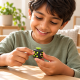 Front view of a child playing with a black plastic multi-sensory fidget cube.