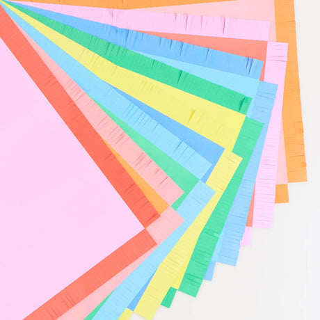 Close-up view of vibrant pastel paper placemats with fringed edges fanned out in a arc.