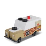 Candycar Gira Drifter wooden toy truck with giraffe print, white camper top, and spare tires on a white background.