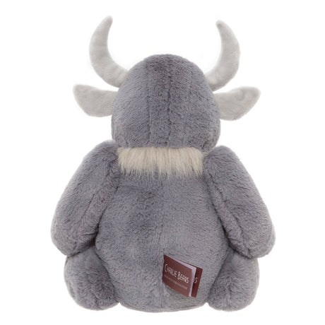 Back view of a plush grey horned creature toy sitting down, showing curved horns, soft fur, and a fabric tag.