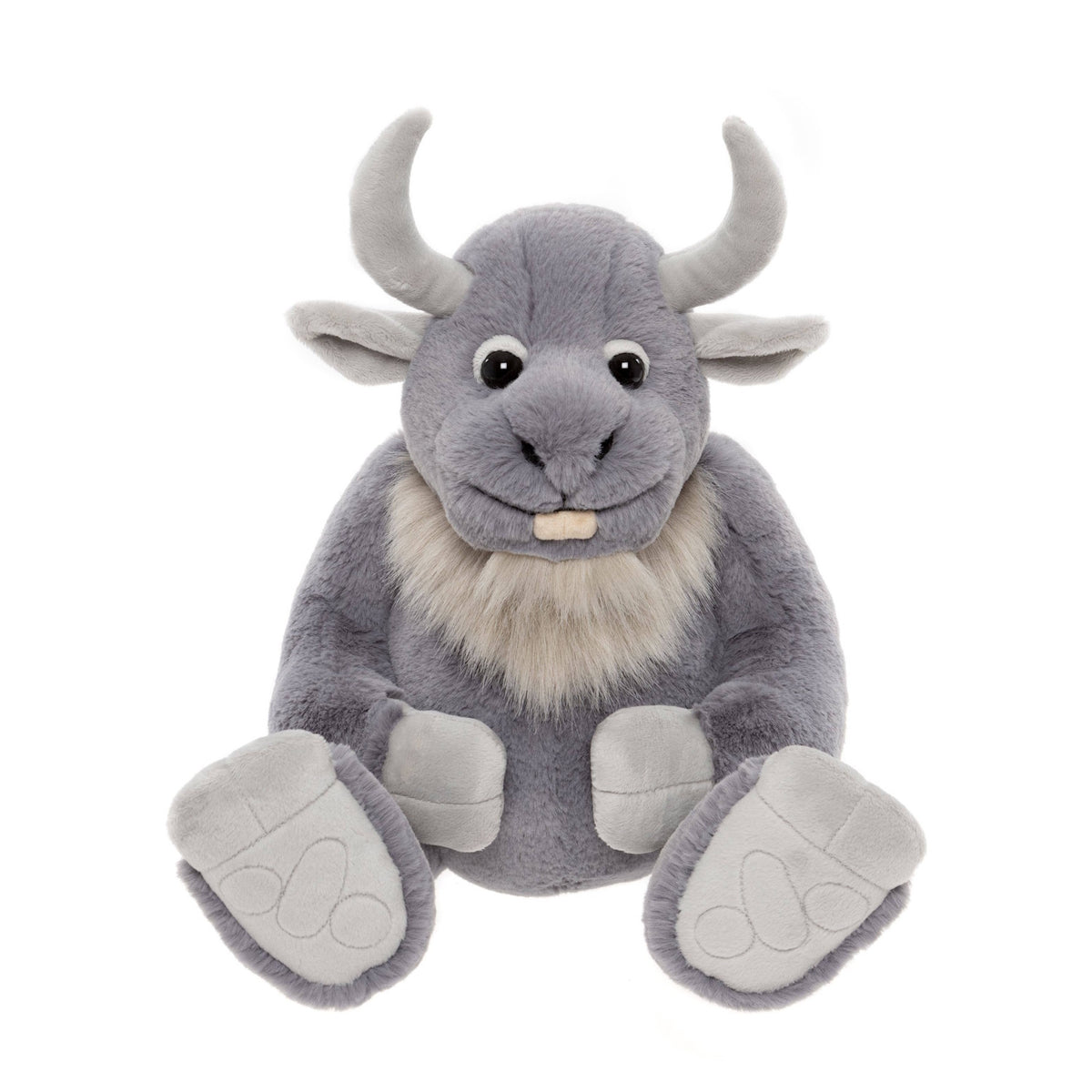 Front view of a plush grey horned creature toy sitting down, showing curved horns, beard, and big foot pads.