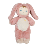 Cozy Dinkum doll Bunny Pinkie wearing a plush pink rabbit outfit with floppy ears against a white background.
