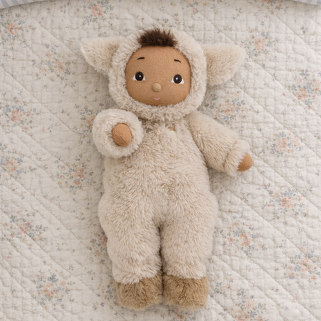 Olli Ella Cozy Dinkum Lamby plush doll on a floral quilted blanket.