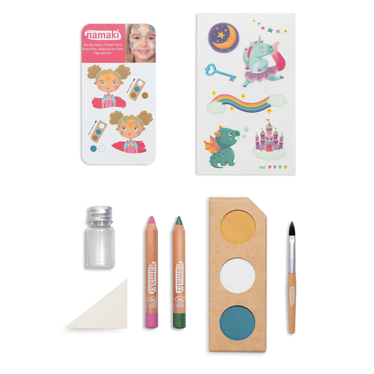 Contents of the Namaki Flower Fairy Face Paint Kit, including organic face paint palette, two coloured pencils, a brush, silver glitter, a sponge, and fairy-themed temporary tattoos.