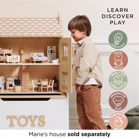 Young boy looking inside a wooden dollhouse filled with miniature furniture.