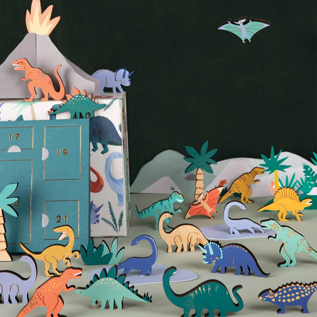 Dinosaur advent calendar set featuring wooden figures, paper palm trees, and an erupting volcano.