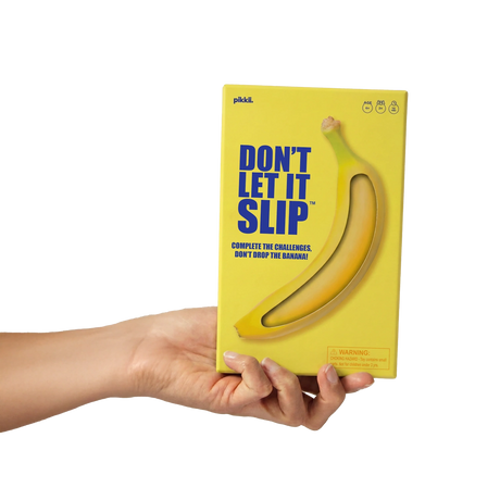 Hand holding the yellow "Don't Let It Slip" game box against a white background.