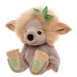 Plush grey troll toy with a fluffy tan mane, large floppy ears, green leaf accent, and large beige feet.