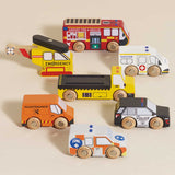 Seven-piece wooden toy emergency vehicle set displayed side-by-side on a light background.