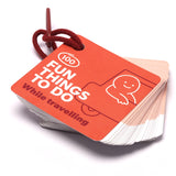 Red "100 Fun Things to Do While Travelling" activity card deck attached to a ring clip.