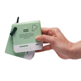 Hand holding a green activity card booklet showing the "Stick Pizza" card prompt.