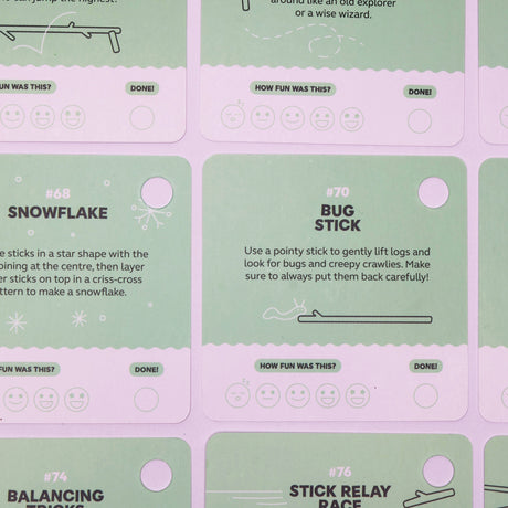 Green activity prompt cards featuring stick ideas like "Snowflake" and "Bug Stick" on a purple surface.