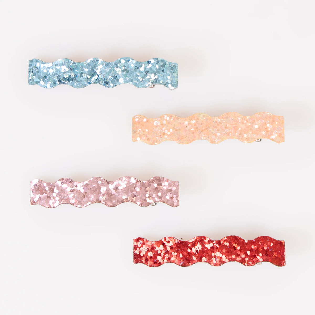 Four wavy glitter hair clips in blue, peach, pink, and red on a white background.