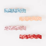 Four wavy glitter hair clips in blue, peach, pink, and red on a white background.
