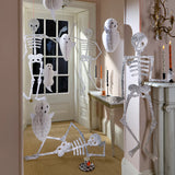 White honeycomb ghost decorations and jointed glitter skeletons styled in a festive interior hallway setting.