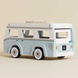 Vintage-style light blue and white wooden toy camper van with a surfboard on top.