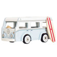 Light blue and white wooden toy camper van with a surf board leaning on its side.