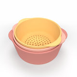 Three pastel silicone bowls; one yellow with holes as a colander, two solid pink, nested together. Minimalist design on a white background.