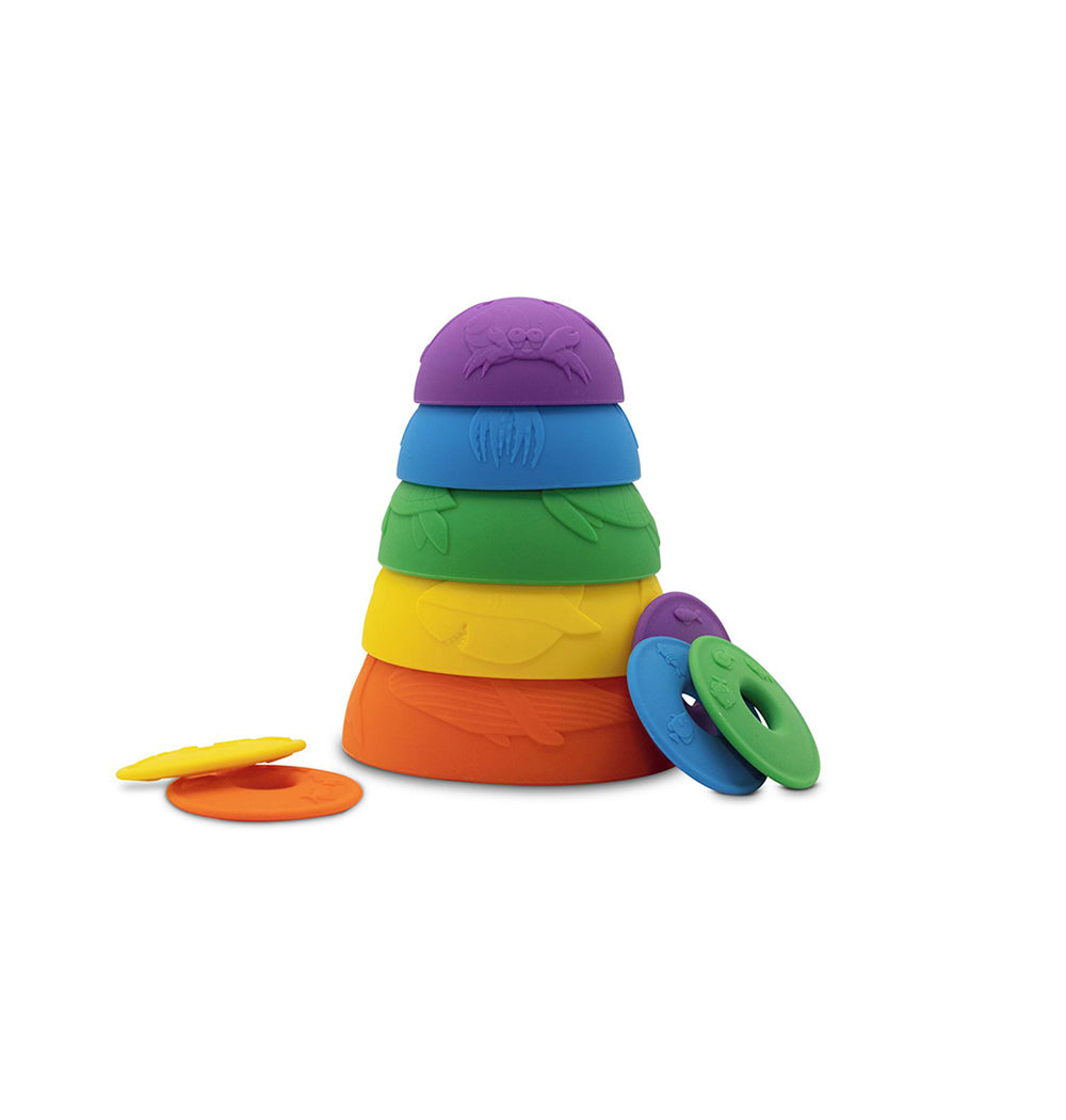 A set of vibrant, ocean-themed stacking cups in rainbow colours, with some cups slightly unstacked and matching discs scattered around.