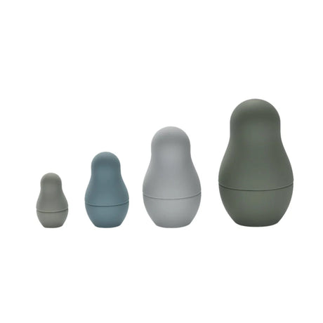 Four silicone nesting dolls in muted grey and blue tones lined up in a front view.